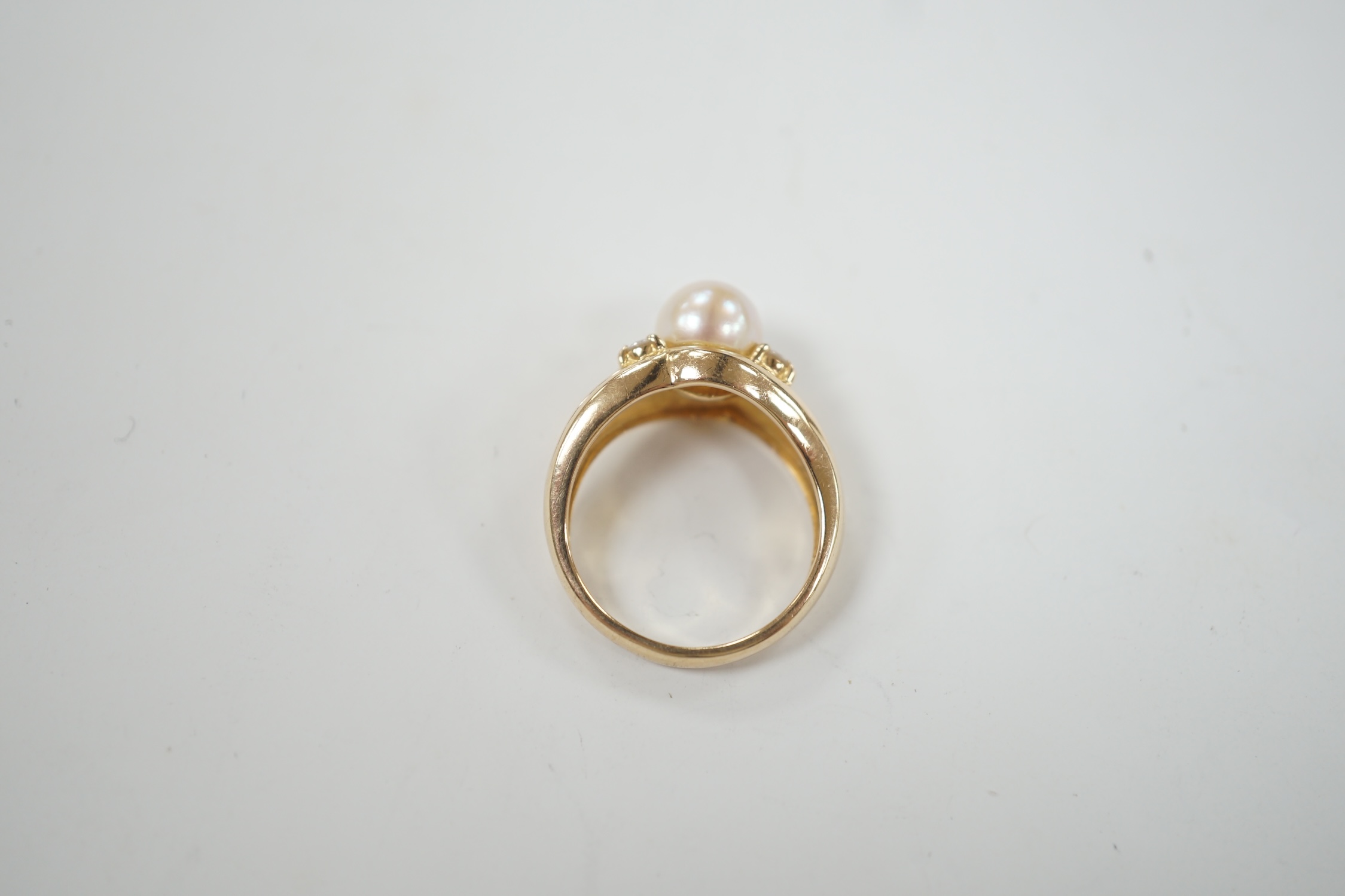 A modern 585 yellow metal, single stone cultured pearl and four stone diamond set ring, size I, gross weight 3.9 grams.